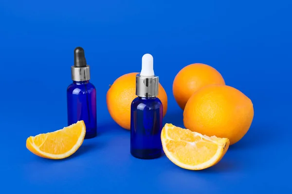 Bottles Essential Oil Fresh Oranges Blue Background — Stock Photo, Image