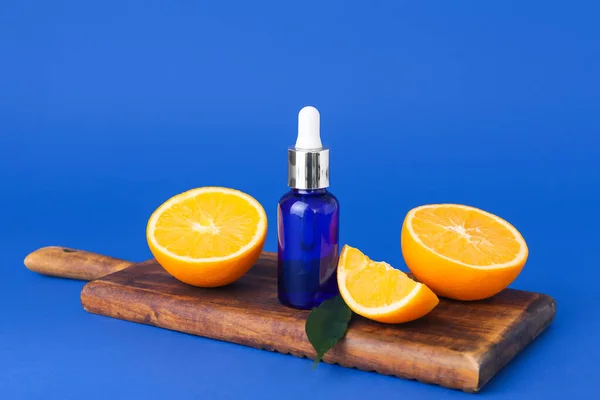 Botella Aceite Esencial Naranja Fresca Sobre Fondo Azul —  Fotos de Stock