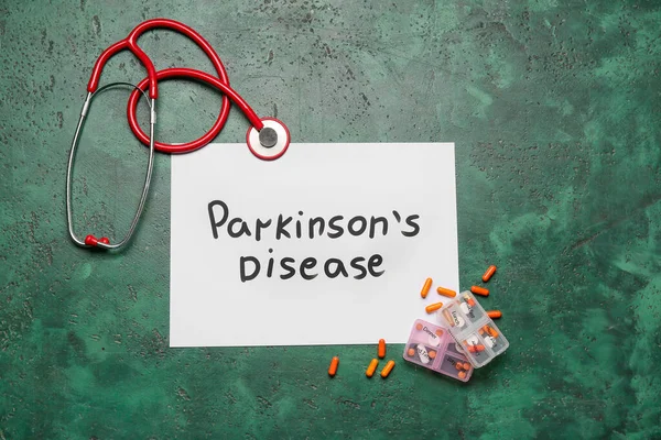 Parkinson Hastalığı, steteskop ve yeşil arka planda haplar içeren kağıt kağıtlar.