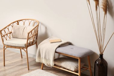 Hasır koltuklu, yumuşak banklı ve vazolu aydınlatma odasının içi