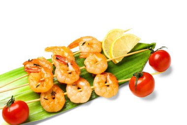 Limonlu ızgara karides şişi ve beyaz arka planda domates.