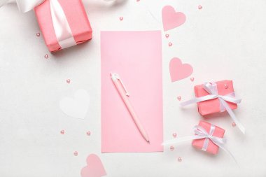 Açık arkaplanda Sevgililer Günü için boş kağıt çarşaf ve hediye kutuları