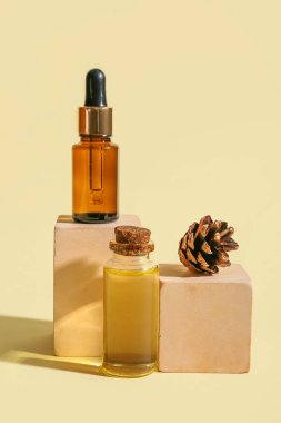 Gerekli yağ şişeleri ve renk arkaplan üzerinde çam kozalağı bileşimi