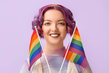 Renkli arkaplanda LGBT bayrakları olan genç bir kadın