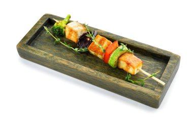 Beyaz arka planda ızgara tofu peyniri şişi olan tahta