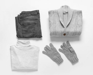 Beyaz arka planda erkek kazakları, eldivenler ve pantolonlar.