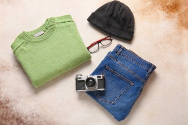 Erkek giysileri, gözlükler ve arka planda fotoğraf makinesi.