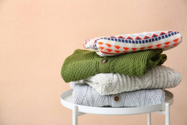 Renk duvarının yanındaki masada kazak yığını