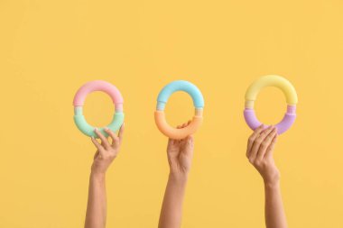 Renkli arka planda popüler pop tüpleri olan eller