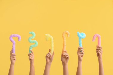 Renkli arka planda popüler pop tüpleri olan eller