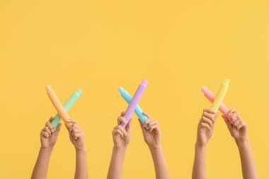 Renkli arka planda popüler pop tüpleri olan eller