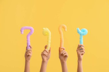 Renkli arka planda popüler pop tüpleri olan eller