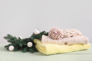 Örgü süveterler, şapka ve Noel dekoru açık arkaplanda ahşap masa.