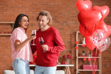 Sevgililer Günü 'nde evde şarap içen mutlu genç çift.