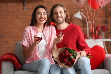 Sevgililer Günü 'nde evde şarap içen mutlu nişanlı çift.