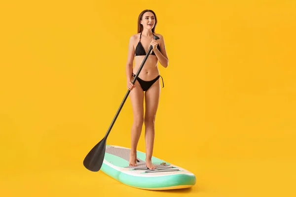Mladá Žena Deskou Pro Sup Surfování Veslo Barevném Pozadí — Stock fotografie