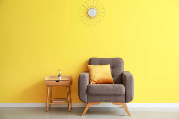 Yastıklı Yumuşak Koltuk Sarı Duvarın Yanındaki Ahşap Masa — Stok fotoğraf