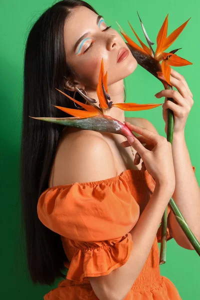 Schöne Junge Frau Mit Strelitzia Blumen Auf Farbigem Hintergrund — Stockfoto