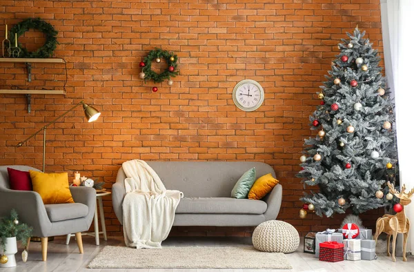 风格别致的室内装饰 沙发上挂着圣诞树 砖墙上挂着钟 — 图库照片
