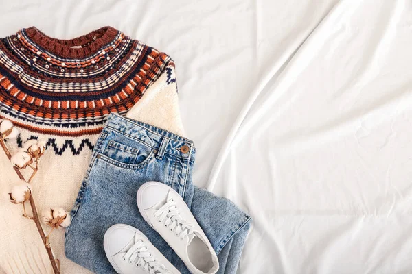 浅色面料背景上的时髦毛衣 牛仔裤 鞋子和棉花 — 图库照片