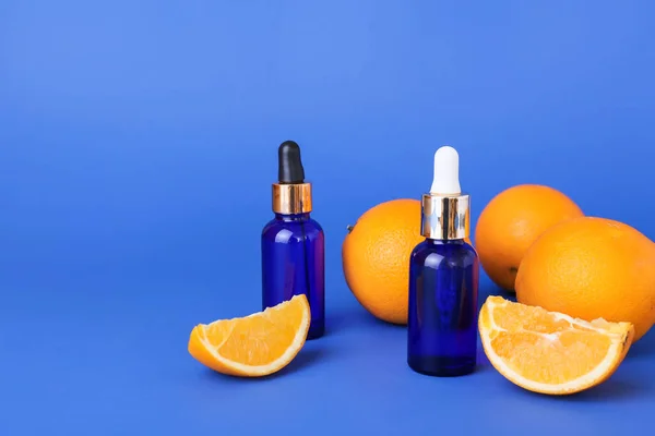 Botellas Aceite Esencial Naranjas Frescas Sobre Fondo Azul —  Fotos de Stock