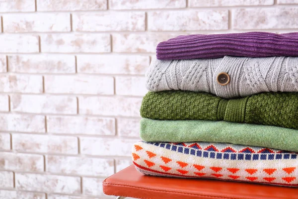 Stack Stylish Sweaters Chair Light Brick Wall — Stock Photo, Image