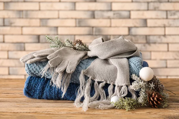 Knitted Sweaters Scarf Fir Tree Branches Wooden Table Brick Wall — Foto Stock