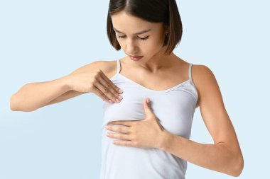 Genç bir kadın arka planda göğsünde rahatsızlık hissediyor. Kanser farkındalığı kavramı