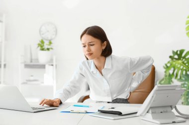 Genç bayan ofiste sırt ağrısı çekiyor.