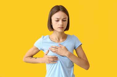 Genç bir kadın, arka planda göğsünde rahatsızlık hissediyor. Kanser farkındalığı kavramı