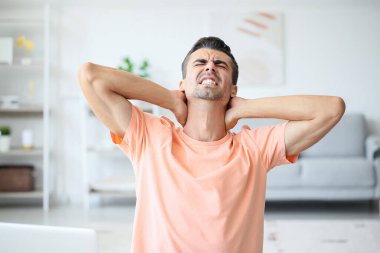 Genç adam evinde boyun ağrısı çekiyor.