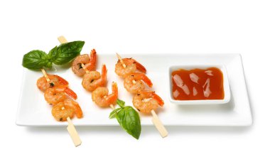 Izgara karides şişi ve beyaz arka planda sos.