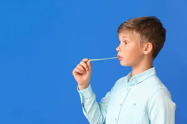 Carino Piccolo Ragazzo Masticare Gomma Sfondo Blu — Foto Stock