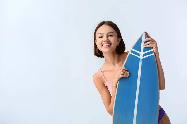 Işık Arka Planında Sörf Tahtası Olan Güzel Genç Bir Kadın — Stok fotoğraf