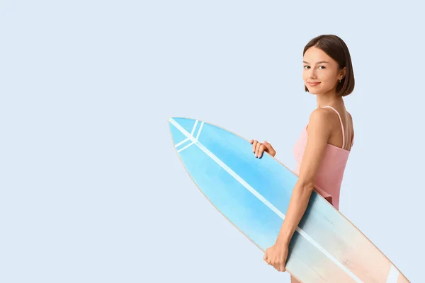 Işık Arka Planında Sörf Tahtası Olan Güzel Genç Bir Kadın — Stok fotoğraf