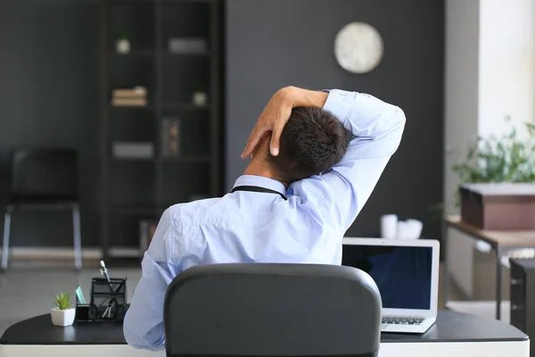 Young Businessman Stretching His Spine While Working Office — стоковое фото