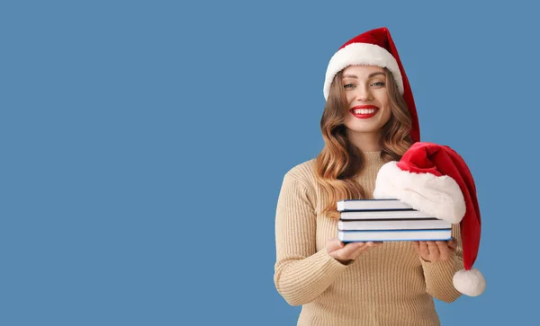 Gelukkig Vrouw Santa Hoed Houden Stapel Van Boeken Kleur Achtergrond — Stockfoto