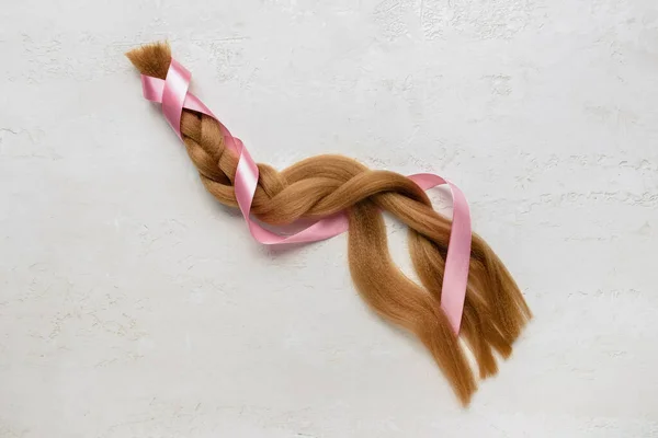 Braided Red Hair Donation Pink Ribbon Light Background — стоковое фото