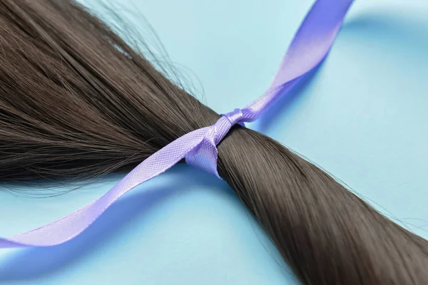 Brunette Hair Strand Donation Lilac Ribbon Blue Background Closeup — Stock Photo, Image