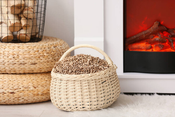 Basket with wood pellets near mantelpiece in living room