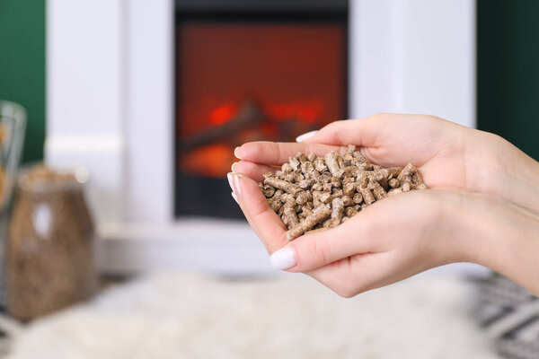 Woman with wood pellets in living room, closeup