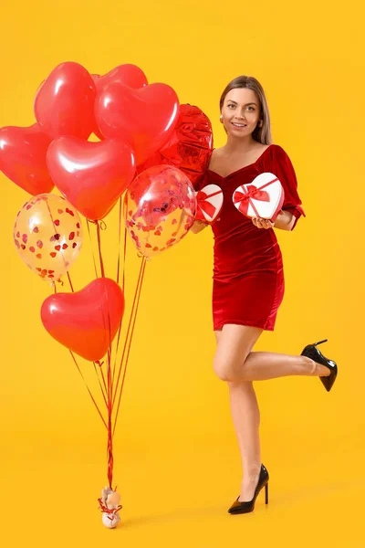 漂亮的年轻女人 有礼物 有彩色背景的气球 情人节庆祝活动 — 图库照片