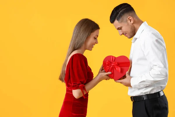 Happy Young Couple Gift Yellow Background Valentine Day Celebration — Zdjęcie stockowe