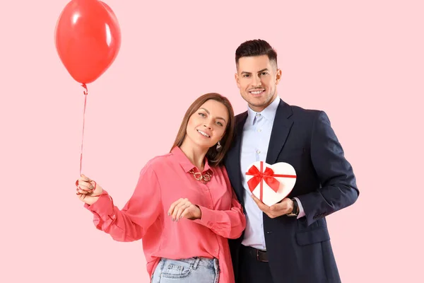 Glückliches Junges Paar Mit Geschenk Und Luftballon Auf Farbigem Hintergrund — Stockfoto