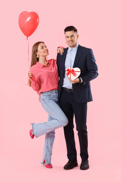 Glückliches Junges Paar Mit Geschenk Und Luftballon Auf Farbigem Hintergrund — Stockfoto