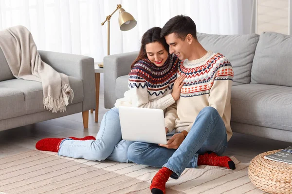 Happy Young Couple Warm Sweaters Using Laptop Home — стоковое фото