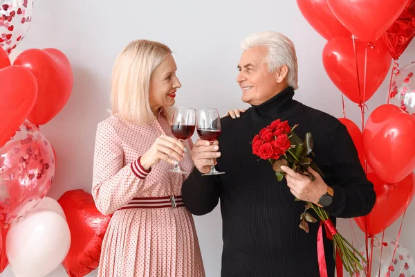 Happy Mature Couple Flowers Wine Light Background Valentine Day Celebration — стоковое фото