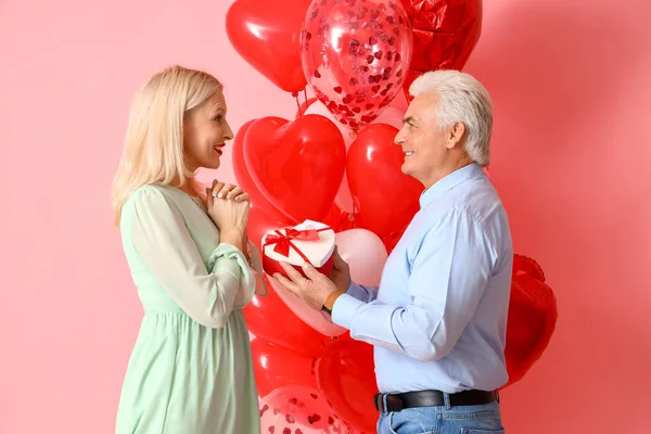 Happy Mature Man Greeting His Wife Valentine Day Color Background — стоковое фото