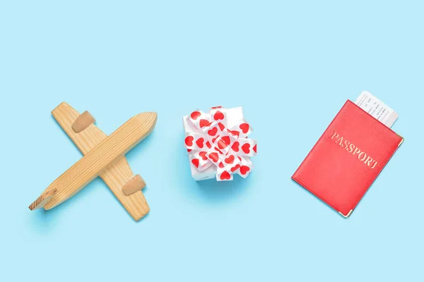 青い背景にギフトとパスポートを持つ木製の飛行機 バレンタインデーのお祝い — ストック写真