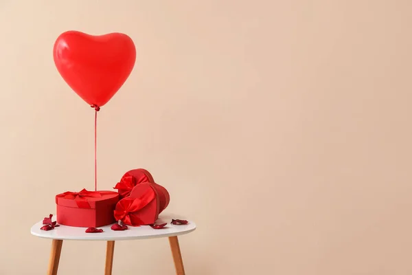 バレンタインデーのプレゼントとカラー背景の風船付きテーブル — ストック写真